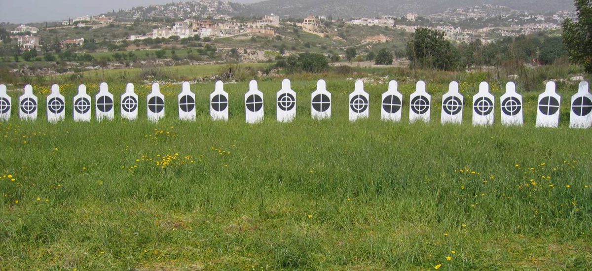 White human figures in line with black targets on their chest