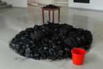 A mount of charcoal, a table and a red bucket
