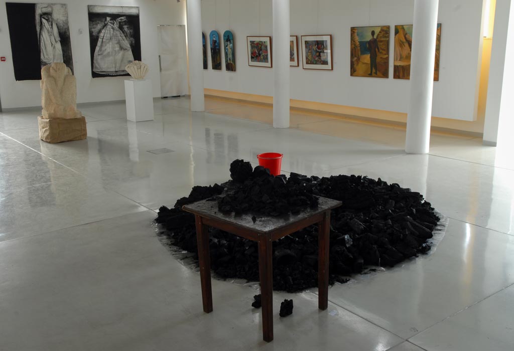 A mount of charcoal, a table and a red bucket