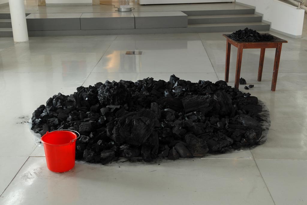 A mount of charcoal, a table and a red bucket