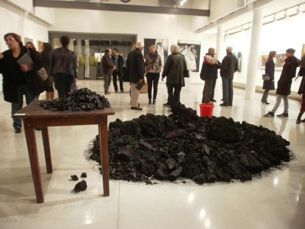 A mount of charcoal, a table and a red bucket